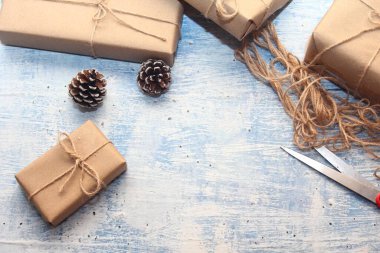 İplikle sarılmış Kraft kağıdından hediye paketi, el yapımı konsept, açık mavi masa üstü.