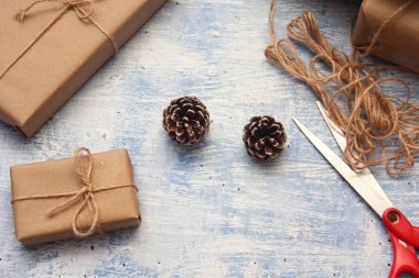 İplikle sarılmış Kraft kağıdından hediye paketi, el yapımı konsept, açık mavi masa üstü.