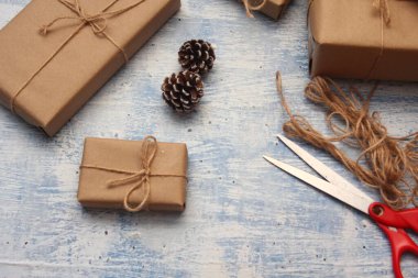 İplikle sarılmış Kraft kağıdından hediye paketi, el yapımı konsept, açık mavi masa üstü.