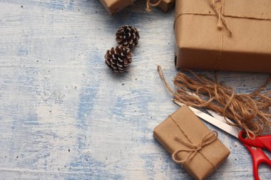 İplikle sarılmış Kraft kağıdından hediye paketi, el yapımı konsept, açık mavi masa üstü.