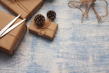 İplikle sarılmış Kraft kağıdından hediye paketi, el yapımı konsept, açık mavi masa üstü.