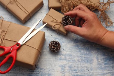 İplikle sarılmış Kraft kağıdından hediye paketi, el yapımı konsept, açık mavi masa üstü.