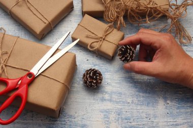 İplikle sarılmış Kraft kağıdından hediye paketi, el yapımı konsept, açık mavi masa üstü.