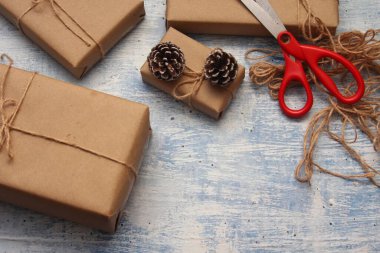 İplikle sarılmış Kraft kağıdından hediye paketi, el yapımı konsept, açık mavi masa üstü.