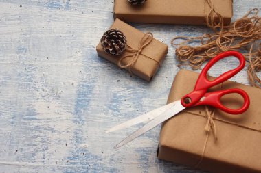 İplikle sarılmış Kraft kağıdından hediye paketi, el yapımı konsept, açık mavi masa üstü.