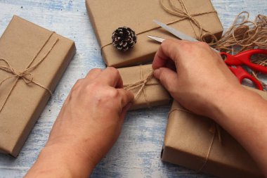 İplikle sarılmış Kraft kağıdından hediye paketi, el yapımı konsept, açık mavi masa üstü.