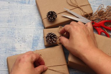 İplikle sarılmış Kraft kağıdından hediye paketi, el yapımı konsept, açık mavi masa üstü.