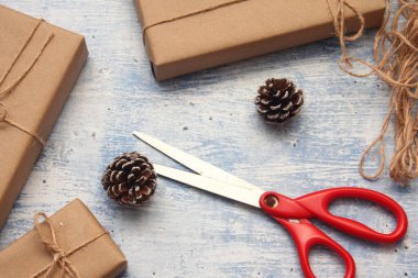 İplikle sarılmış Kraft kağıdından hediye paketi, el yapımı konsept, açık mavi masa üstü.