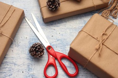 İplikle sarılmış Kraft kağıdından hediye paketi, el yapımı konsept, açık mavi masa üstü.