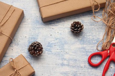 İplikle sarılmış Kraft kağıdından hediye paketi, el yapımı konsept, açık mavi masa üstü.