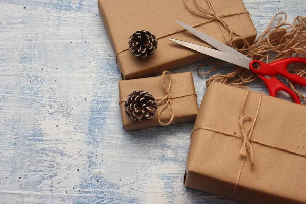 gift wrapping from Kraft paper wrapped with twine, the concept of handmade, light blue tabletop.