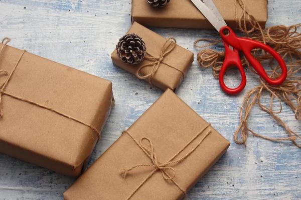 İplikle sarılmış Kraft kağıdından hediye paketi, el yapımı konsept, açık mavi masa üstü.