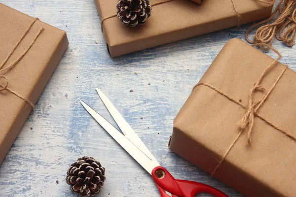 İplikle sarılmış Kraft kağıdından hediye paketi, el yapımı konsept, açık mavi masa üstü.