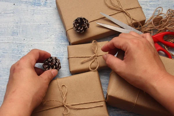 gift wrapping from Kraft paper wrapped with twine, the concept of handmade, light blue tabletop.