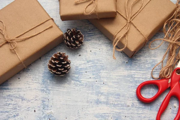 İplikle sarılmış Kraft kağıdından hediye paketi, el yapımı konsept, açık mavi masa üstü.