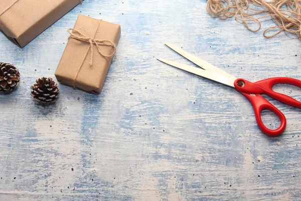 İplikle sarılmış Kraft kağıdından hediye paketi, el yapımı konsept, açık mavi masa üstü.