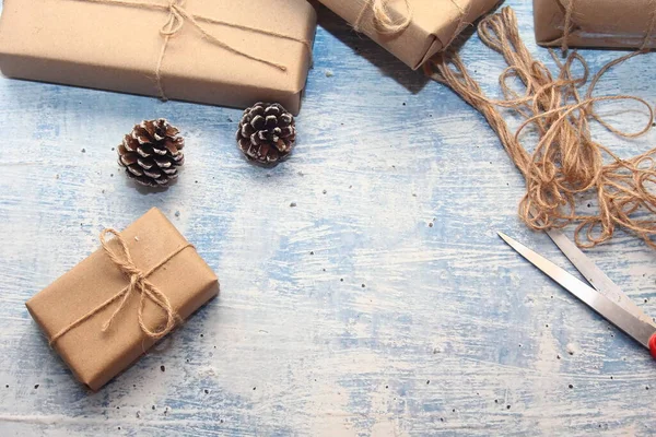 İplikle sarılmış Kraft kağıdından hediye paketi, el yapımı konsept, açık mavi masa üstü.