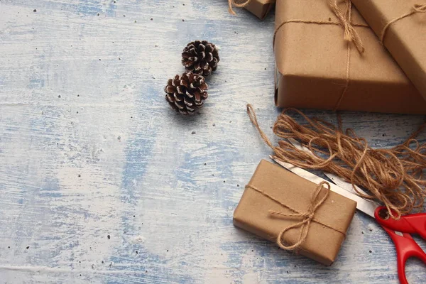 İplikle sarılmış Kraft kağıdından hediye paketi, el yapımı konsept, açık mavi masa üstü.