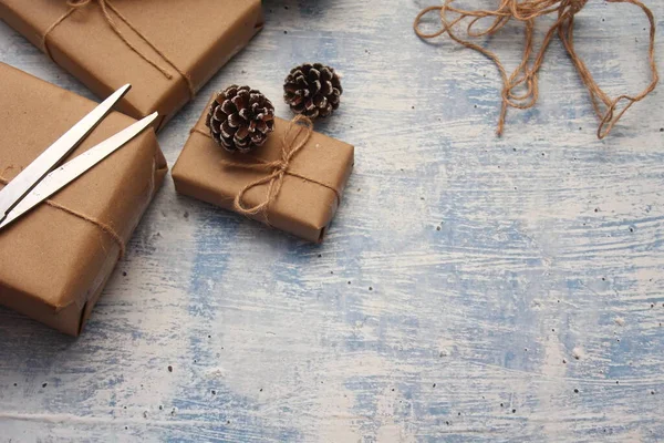 İplikle sarılmış Kraft kağıdından hediye paketi, el yapımı konsept, açık mavi masa üstü.