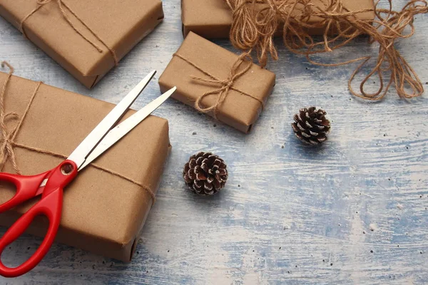 gift wrapping from Kraft paper wrapped with twine, the concept of handmade, light blue tabletop.