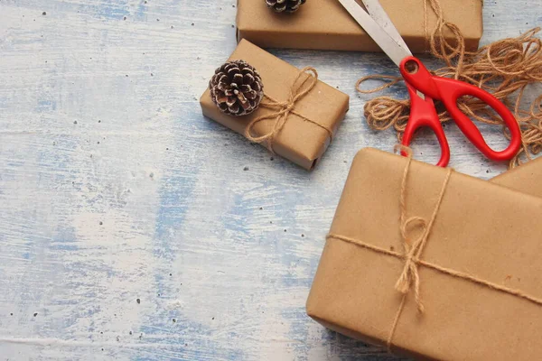 İplikle sarılmış Kraft kağıdından hediye paketi, el yapımı konsept, açık mavi masa üstü.