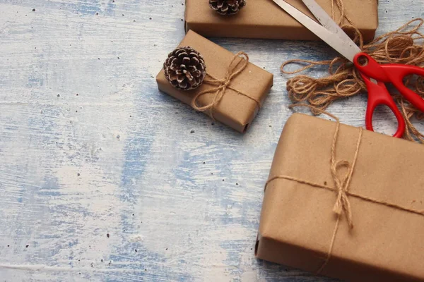 İplikle sarılmış Kraft kağıdından hediye paketi, el yapımı konsept, açık mavi masa üstü.
