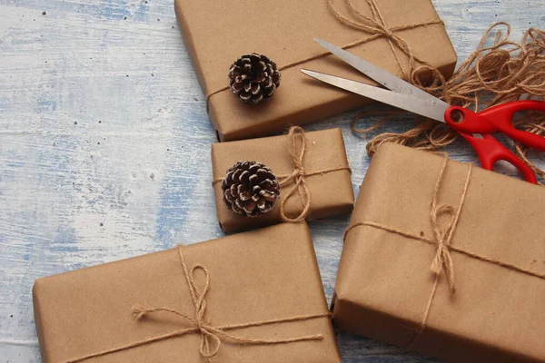 gift wrapping from Kraft paper wrapped with twine, the concept of handmade, light blue tabletop.