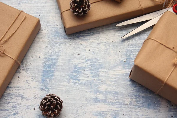 İplikle sarılmış Kraft kağıdından hediye paketi, el yapımı konsept, açık mavi masa üstü.