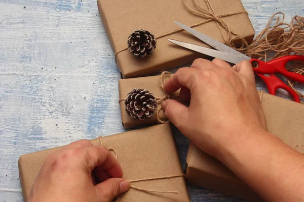 İplikle sarılmış Kraft kağıdından hediye paketi, el yapımı konsept, açık mavi masa üstü.