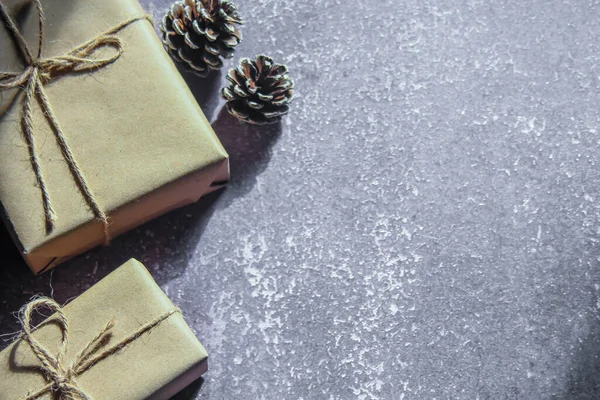 gift wrapping from Kraft paper wrapped with twine, the concept of handmade, put on a gray table