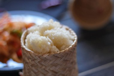 Baharatlı papaya salatası mavi bir tabakta, kovada pilav ve uzun fasulye, kurutulmuş kırmızı biber ve sebze ile servis edilir..