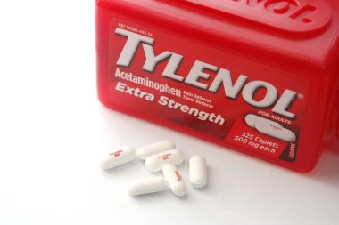 WA-AMERICA - SEP 11 2025: Kırmızı Tylenol Extra güçlü bir şişe ve el değmemiş beyaz arka planda birkaç beyaz başlık yakın çekim.