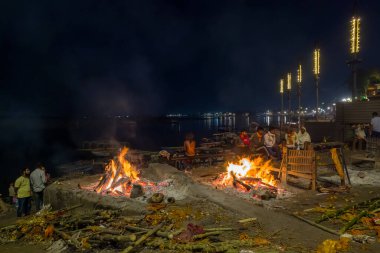Varanasi, Inde - 03 19 2024: Güneşli bir günde, Varanasi, Hindistan, Uttar Pradesh, Varanasi 'de geceleyin Manikarnika ghat' ta yakma işlemi. .