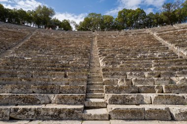 Epidaurus, Grece - 09 02 2024: Avrupa, Yunanistan ve Peloponnese 'deki Asclepius Sığınağı' ndaki Epidaurus Tiyatrosu, güneşli bir günde. .