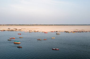 Varanasi, Inde - 03 17 2024: Varanasi, Hindistan, Uttar Pradesh, Varanasi 'deki Ganj Nehri' ndeki tekneler güneşli bir günde. .
