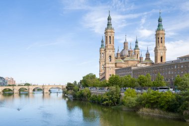 Zaragoza, Espagne - 05 10 2024: The Basilica of Our Lady of the Pillar and the Stone Bridge in Zaragoza, Spain, Aragon, Zaragoza, in a summer day, in a sun day. .