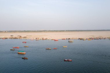 Varanasi, Inde - 03 17 2024: Varanasi, Hindistan, Uttar Pradesh, Varanasi 'deki Ganj Nehri' ndeki tekneler güneşli bir günde. .