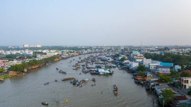 Geniş bir hava manzarası, Güney Vietnam 'daki Can Tho, Mekong Delta' daki hareketli Cai Rang yüzer pazarını yakalar. Nehir boyunca, nehir kenarındaki evler ve yumuşak bir sabah gökyüzünün altında yemyeşil kayıklar toplanıyor..