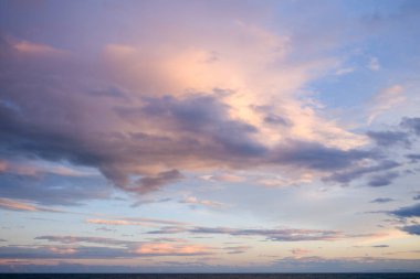 Narin pembe ve lavanta bulutları, sakin Akdeniz üzerinde, Agde yakınlarında sakin bir akşam gökyüzünde sürükleniyor. Yumuşak ışık huzurlu, rüya gibi bir sahil atmosferi yaratır..