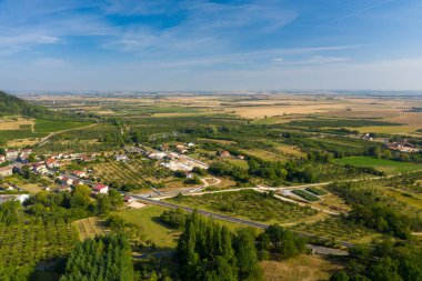 Saint-Maurice-sous-les-Cotes köyünün hava manzarası açık bir gökyüzü altında bahçeler, yama alanları ve dolambaçlı kırsal yollar ile çevrilidir. Manzarada geniş tarım arazileri, dağınık evler ve sınırdaki yeşil ormanlar yer almaktadır.