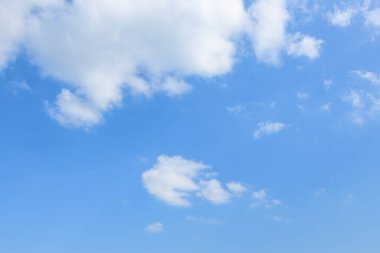 Yumuşak kümülüs bulutları canlı mavi bir gökyüzünde süzülerek havadar ve sakin bir zemin oluşturur. Parlak gün ışığı açıklık ve sükuneti arttırır..