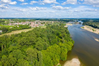 Loire Nehri 'ni çevreleyen yoğun yeşil ormanlı Pouilly sur Loire' ın hava perspektifi, kumlu bankalar ve dağınık bulutlarla dolu bir gökyüzünün altındaki köy çatıları kümesi. Titreşimli manzara huzur ve doğal güzellik yayıyor..