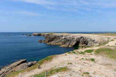 Geniş kayalık burunlar, Saint Pierre Quiberon 'daki Pointe Beg-An-Aud' daki derin mavi Atlantik 'e kayalık taşlarla, yumuşak sörflerle ve parlak, berrak gökyüzüyle çarpışıyor..