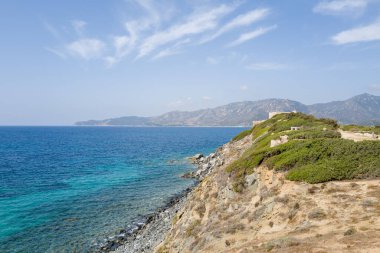 Capo Carbonara 'da güneşli, kayalık bir burnun tepesinde, parlak turkuaz sulara ve berrak mavi gökyüzünün altındaki uzak sıradağlara bakan tarihi bir taş kale bulunur..
