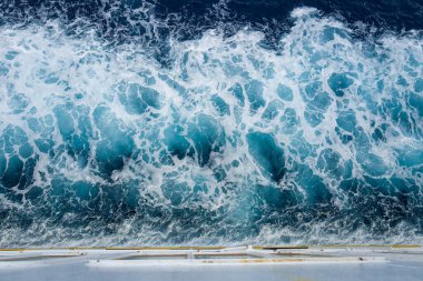 Akdeniz 'deki bir feribotun arkasında dönen turkuaz ve beyaz köpük görüntüsü. Enerjik su desenleri ve zengin mavi renkler çarpıcı bir deniz soyutu yaratır..