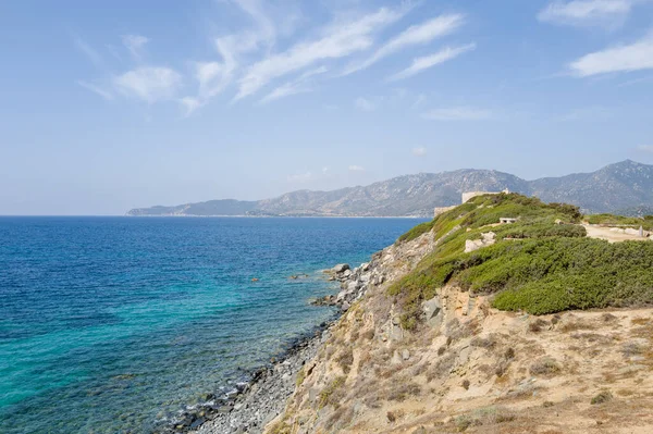 Capo Carbonara 'da güneşli, kayalık bir burnun tepesinde, parlak turkuaz sulara ve berrak mavi gökyüzünün altındaki uzak sıradağlara bakan tarihi bir taş kale bulunur..