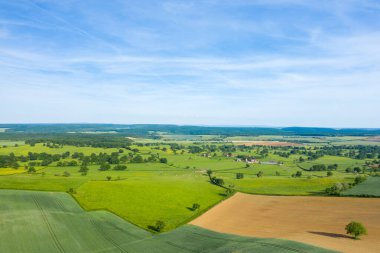 Geniş mavi gökyüzü altında canlı yeşiller ve toprak tonları ile, Cuncy les Varzy yakınlarındaki kırsal kırsal arazi ve dağınık ağaçlar hava görünümlü.