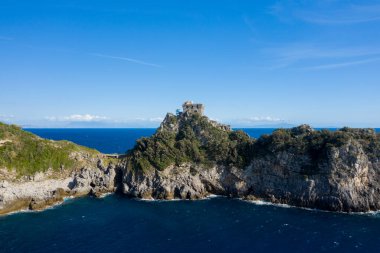 Tarihi bir taş gözetleme kulesi İtalya 'nın gür Capo di Conca bölgesini, yemyeşil Akdeniz bitkileri ve derin mavi denizlerle çevrili olarak taçlandırır. Dramatik kıyı şeridi berrak bir gökyüzünün altında, doğal güzelliği vurguluyor.