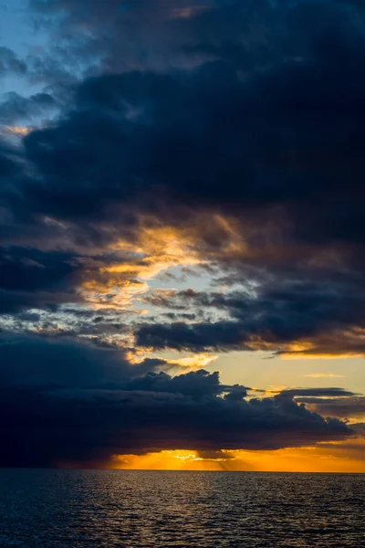 Adriyatik Denizi 'nin üzerinde gün batımında etkileyici bir kara bulutlar gökyüzü açılıyor. Sahne, aydınlık ufuk ve durgun suyun üzerindeki derin gölge arasındaki çarpıcı zıtlıkları gösteriyor..