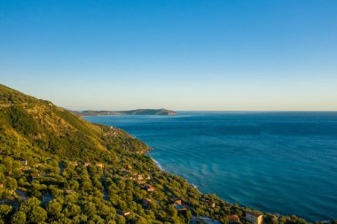 Pisciottas 'ın hava manzarası berrak bir gökyüzünün altındaki canlı mavi Akdeniz' e iniyor. Dağınık evler, güneşli sahil şeridi boyunca sık yeşillikler arasında yuva yapar..